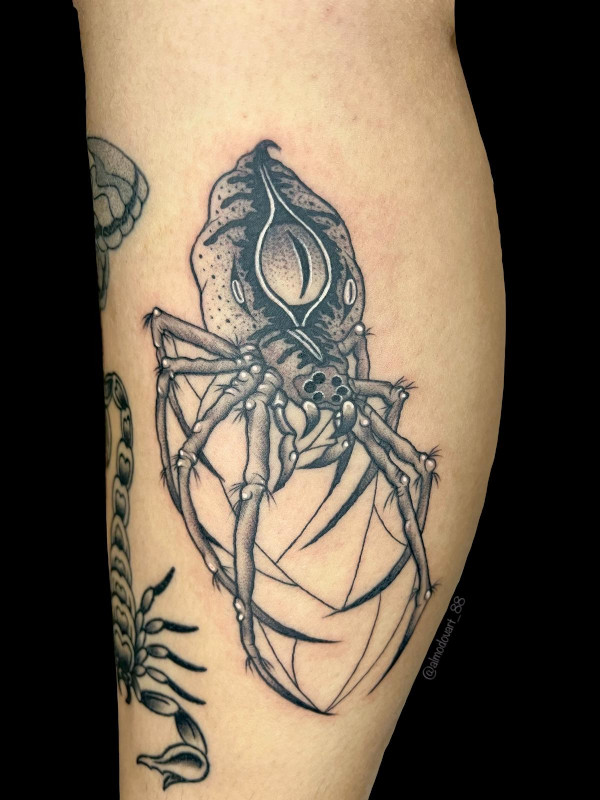 Black, grey and white detailed fine line tattoo of a spider with an eye in its abdomen by Sacred Mandala Studio tattoo artist Lita Almodovar in Durham, NC.